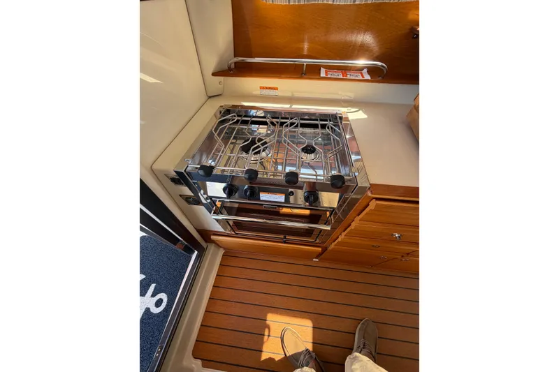 Slide: The Image of Compact kitchen area in 2021 Ranger Tugs R-27 boat with stove and wooden flooring. - 12