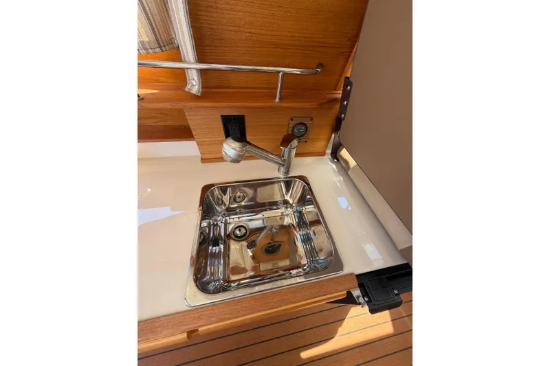 Slide: The Image of Stainless steel sink in 2021 Ranger Tugs R-27 boat interior with wooden accents. - 13