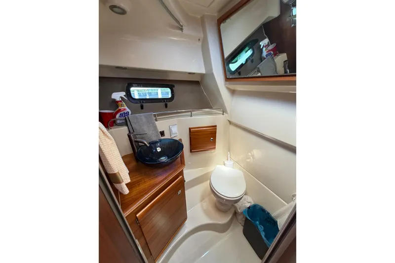 Slide: The Image of 2021 Ranger Tugs R-27 boat bathroom with modern fixtures and wooden cabinetry. - 19