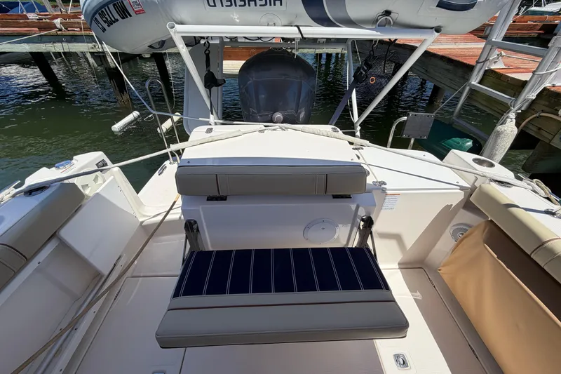Slide: The Image of 2021 Ranger Tugs R-27 boat stern with seating and outboard motor at dock. - 5