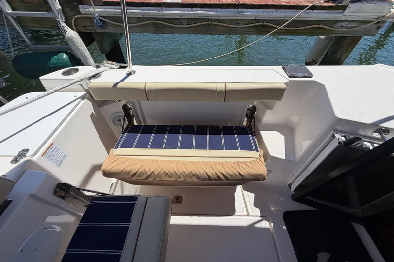 Slide: The Image of 2021 Ranger Tugs R-27 boat cockpit with cushioned seating and dock view. - 6