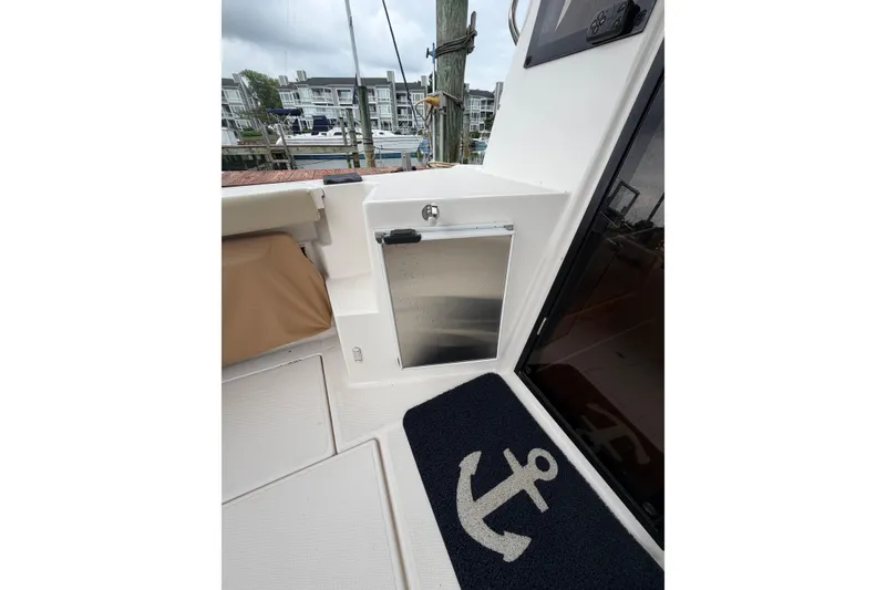 Slide: The Image of 2021 Ranger Tugs R-27 boat interior with anchor-themed mat and dock view. - 7
