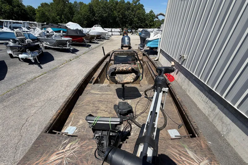 Slide: The Image of 2023 G3 Gator Tough 18 CCJ boat with camouflage design, parked outdoors near other boats. - 10