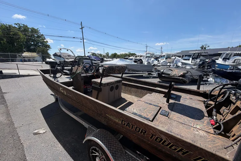 Slide: The Image of 2023 G3 Gator Tough 18 CCJ boat in a dealership lot under clear blue sky. - 3