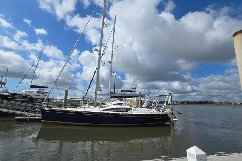Slide: The Image of 2011 Jeanneau Sun Odyssey 50 DS sailboat docked under a partly cloudy sky. - 1