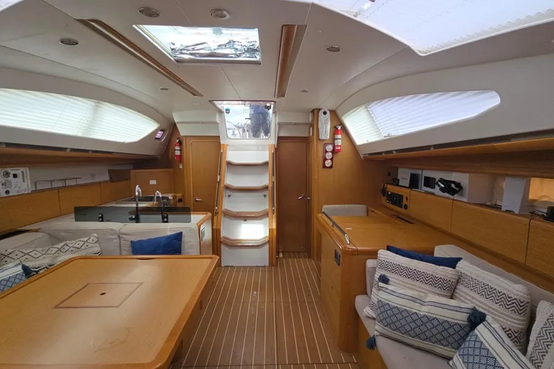 Slide: The Image of Interior of 2011 Jeanneau Sun Odyssey 50 DS yacht, featuring elegant wood finishes and cozy seating. - 69