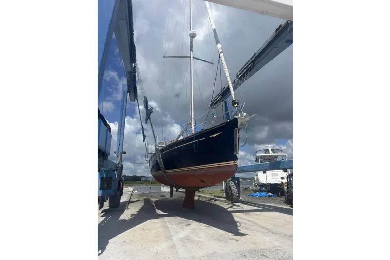 Slide: The Image of 2011 Jeanneau Sun Odyssey 50 DS sailboat lifted by crane under cloudy sky. - 77