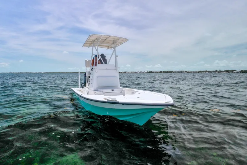 Slide: The Image of 2022 Shallow Sport 24 Modified V boat on open water under clear sky. - 1