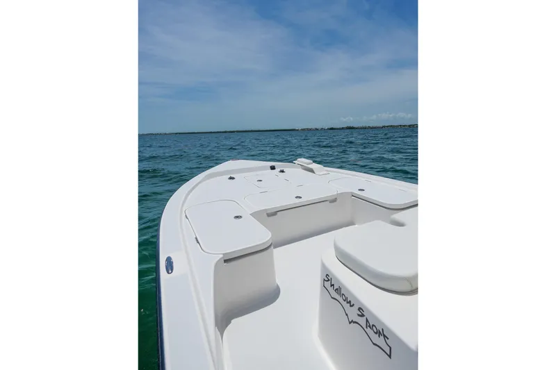Slide: The Image of 2022 Shallow Sport 24 Modified V boat on open water under clear sky. - 13