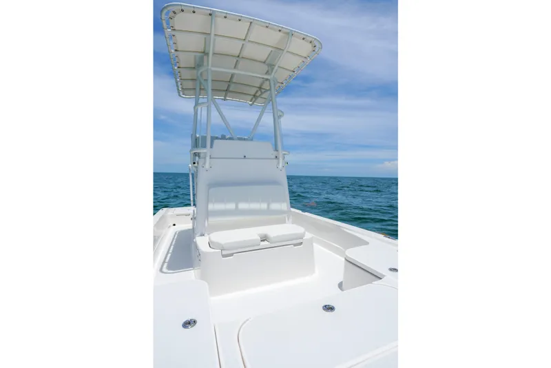 Slide: The Image of 2022 Shallow Sport 24 Modified V boat on open water under blue sky. - 14