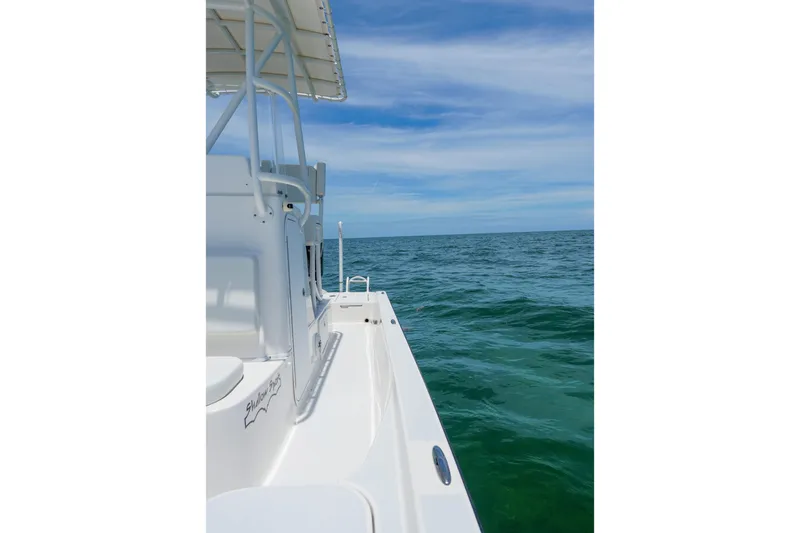 Slide: The Image of 2022 Shallow Sport 24 Modified V boat on open sea under blue sky. - 18