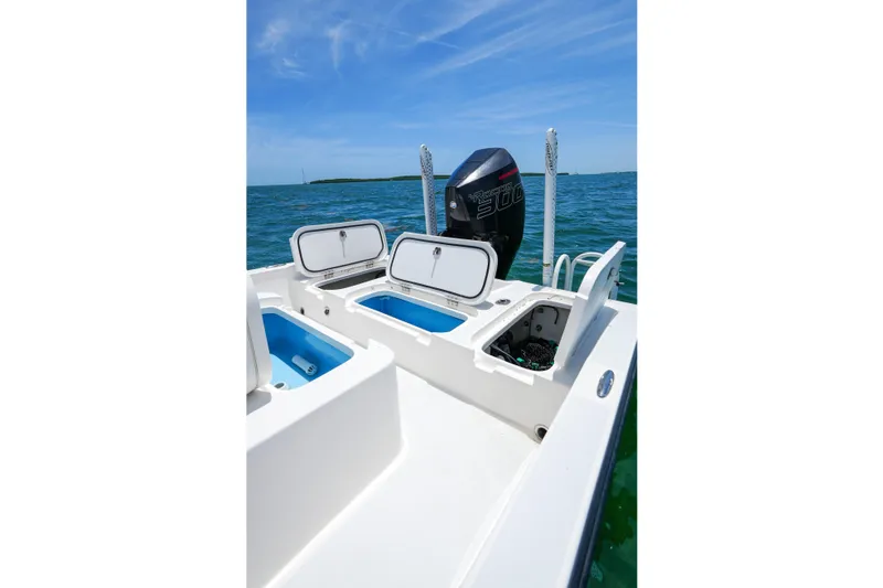 Slide: The Image of 2022 Shallow Sport 24 Modified V boat with open storage compartments on calm water. - 20