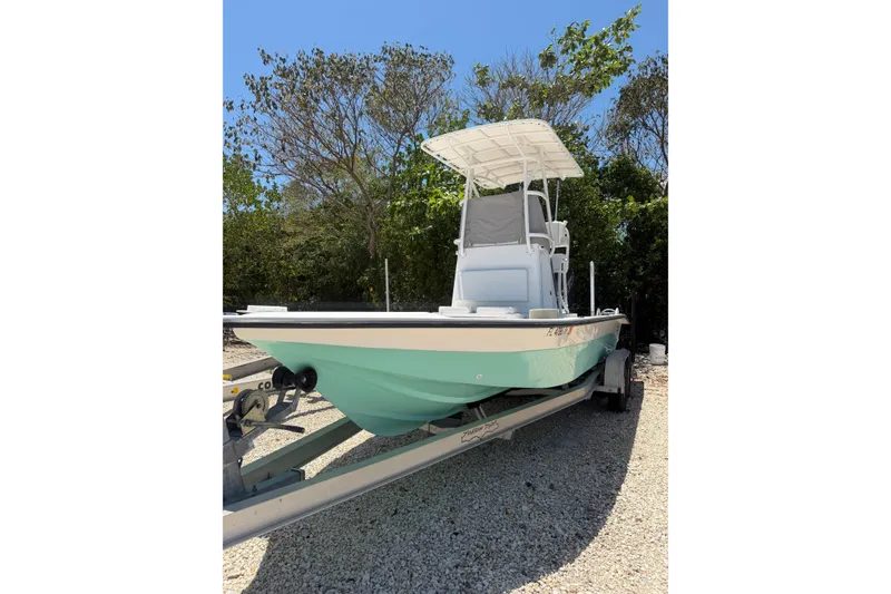 Slide: The Image of 2022 Shallow Sport 24 Modified V boat on trailer, parked outdoors. - 21