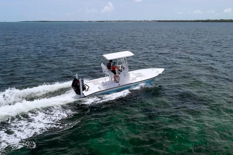 Slide: The Image of 2022 Shallow Sport 24 Modified V boat cruising on open water. - 4