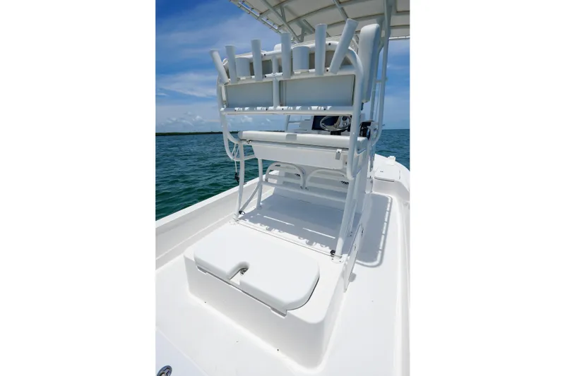 Slide: The Image of 2022 Shallow Sport 24 Modified V boat interior with seating and rod holders on open water. - 9