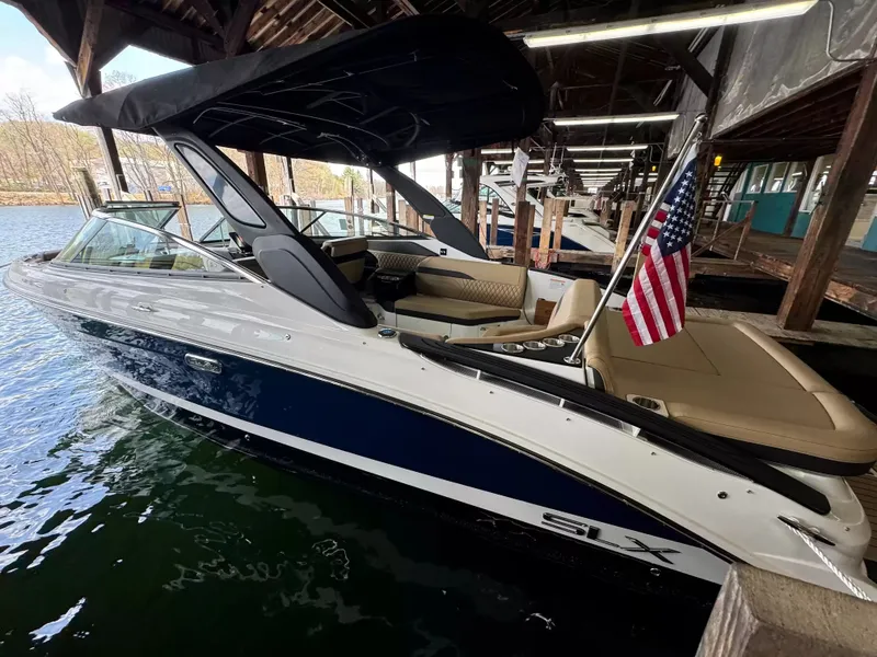 Slide: The Image of 2026 Sea Ray 280SLX boat docked with American flag. - 2