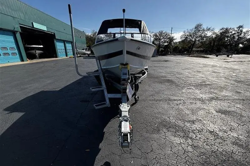 Slide: The Image of 2026 Lund 1875 Crossover XS boat on trailer in parking lot, sunny day. - 4