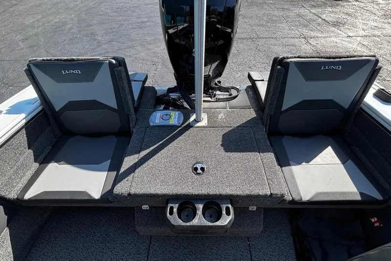 Slide: The Image of 2026 Lund 1875 Crossover XS boat interior with two cushioned seats and storage compartments. - 5