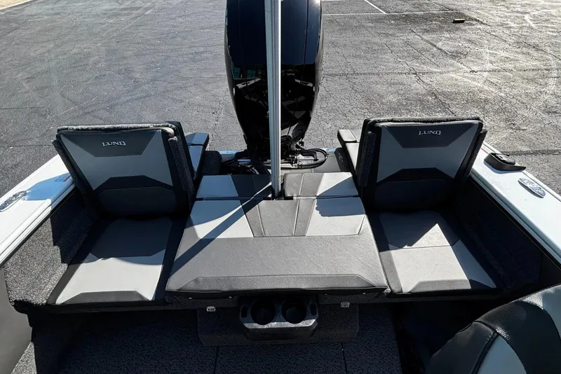 Slide: The Image of 2026 Lund 1875 Crossover XS boat interior with foldable seats and motor. - 6