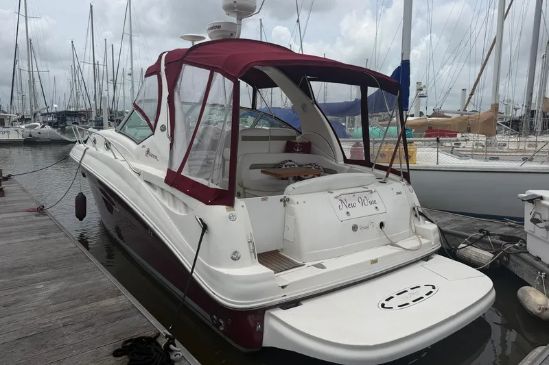 The Image of 2006 Sea Ray Sundancer 320 docked at marina, featuring maroon canopy and sleek design. - 0