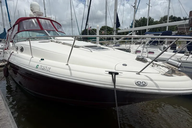 Slide: The Image of 2006 Sea Ray Sundancer 320 docked at marina, featuring sleek design and maroon accents. - 4