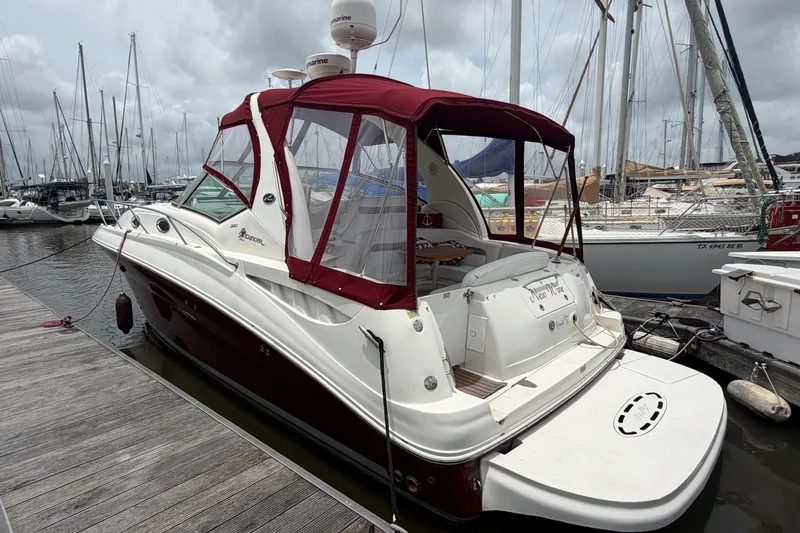 Slide: The Image of 2006 Sea Ray Sundancer 320 docked at marina, featuring maroon canopy and sleek design. - 5