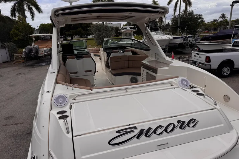 Slide: The Image of 2016 Sea Ray SLX 350 boat with "Encore" name, docked near palm trees. - 10