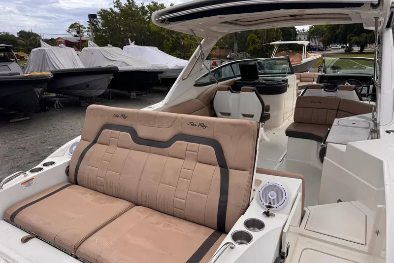 Slide: The Image of 2016 Sea Ray SLX 350 boat interior with tan seating and modern amenities. - 11