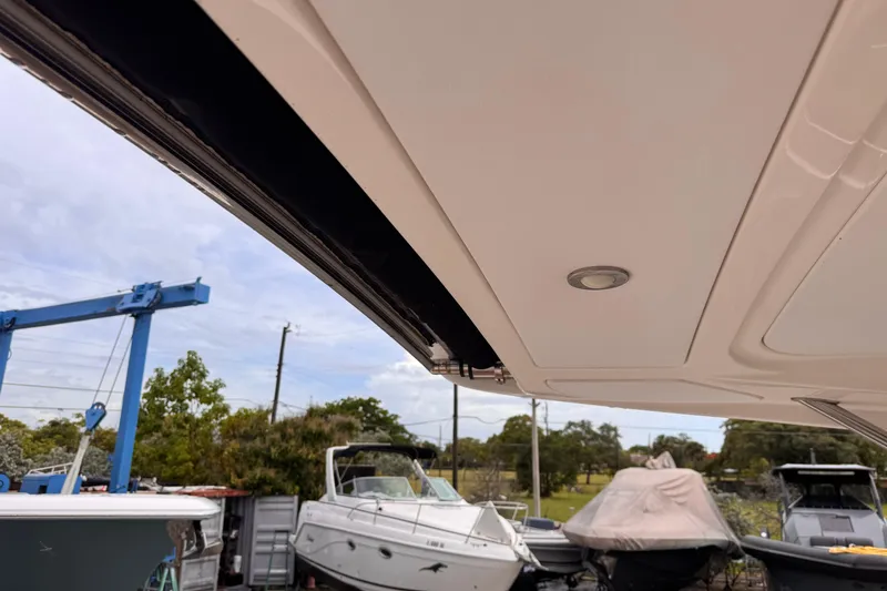 Slide: The Image of 2016 Sea Ray SLX 350 boat interior roof detail with outdoor marina view. - 15