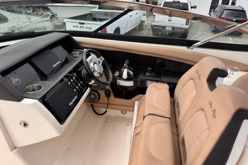 Slide: The Image of 2016 Sea Ray SLX 350 boat cockpit with beige seats and Raymarine electronics. - 16