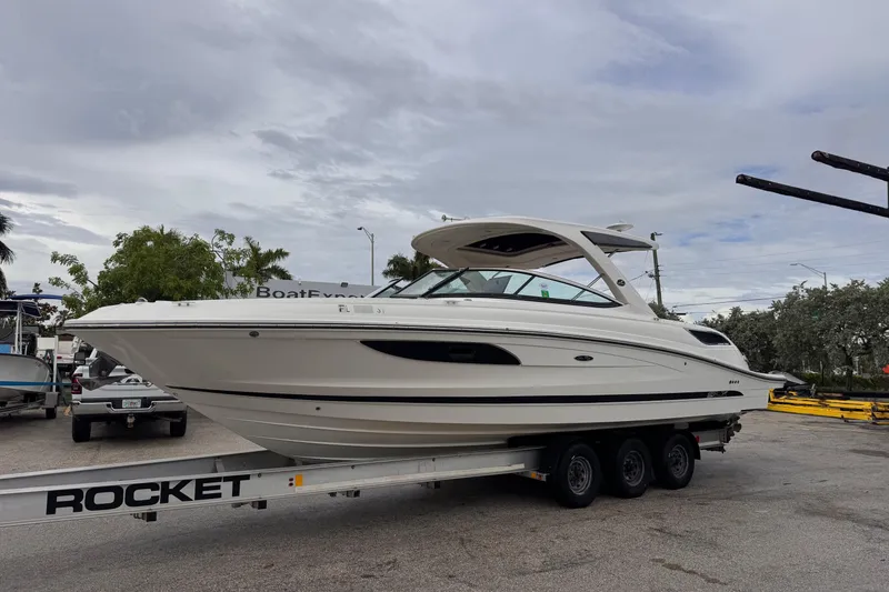 Slide: The Image of 2016 Sea Ray SLX 350 boat on a trailer, parked outdoors under cloudy skies. - 3
