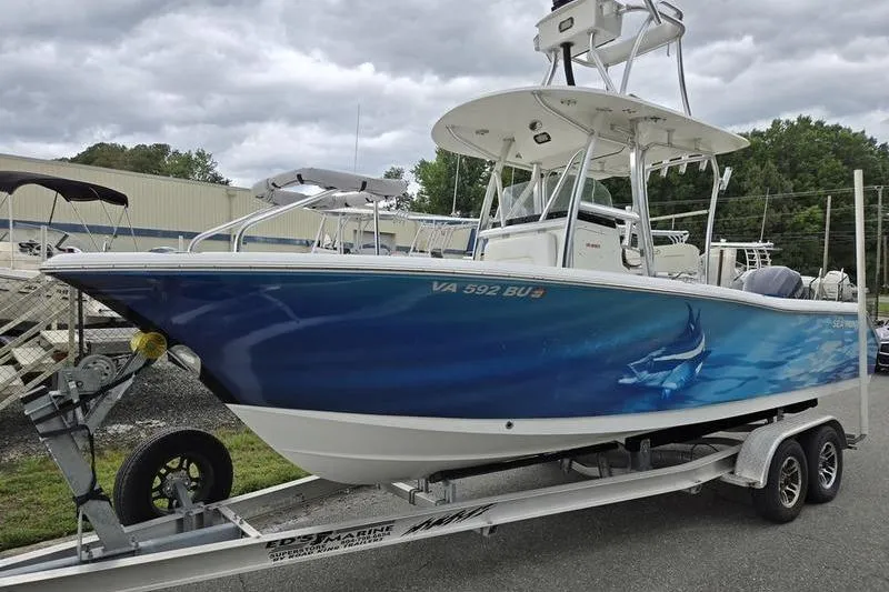 The Image of 2011 Sea Hunt Triton 240 boat on trailer, featuring blue shark-themed hull design. - 0