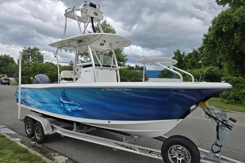 Slide: The Image of 2011 Sea Hunt Triton 240 boat on trailer, featuring a vibrant blue marlin design. - 13