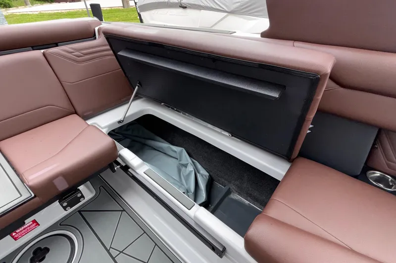 Slide: The Image of 2026 ATX Surf Boats 24 Type-S interior storage compartment with brown seating. - 32