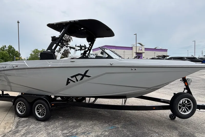 Slide: The Image of 2026 ATX Surf Boats 24 Type-S on trailer, sleek design, parked outdoors. - 4