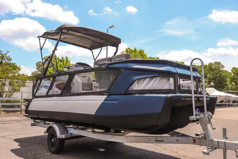 The Image of 2026 Sea-Doo Switch Cruise 21 pontoon boat on trailer, parked outdoors. - 1