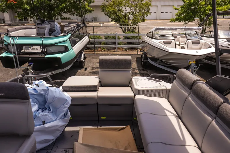 Slide: The Image of 2026 Sea-Doo Switch Cruise 21 pontoon boat parked with other boats in a lot. - 12