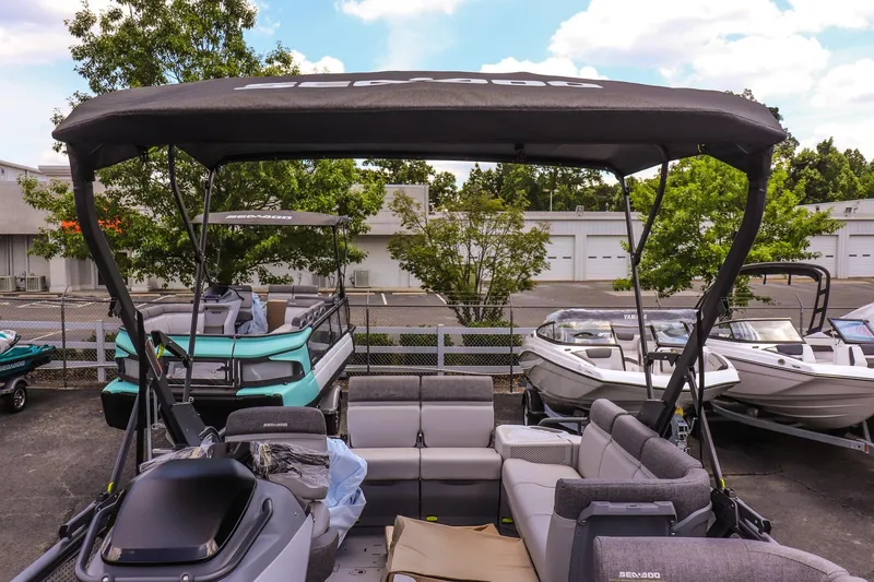 Slide: The Image of 2026 Sea-Doo Switch Cruise 21 pontoon boat with canopy, parked in a marina. - 18