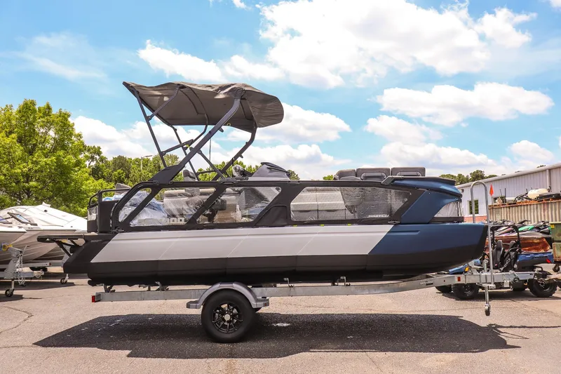Slide: The Image of 2026 Sea-Doo Switch Cruise 21 pontoon boat on trailer under sunny sky. - 2