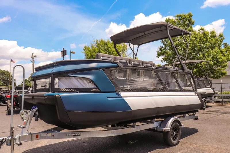 Slide: The Image of 2026 Sea-Doo Switch Cruise 21 pontoon boat on trailer, parked outdoors. - 7