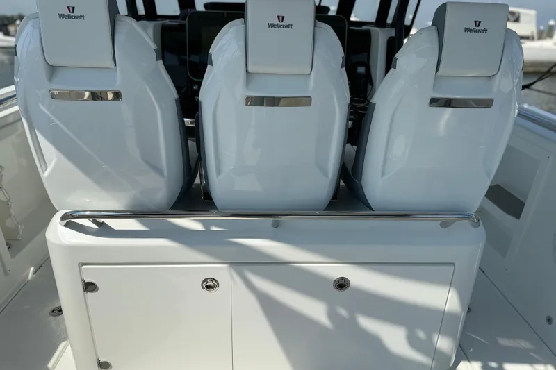 Slide: The Image of 2026 Wellcraft 38 T-Top boat interior with sleek white seating and storage. - 21