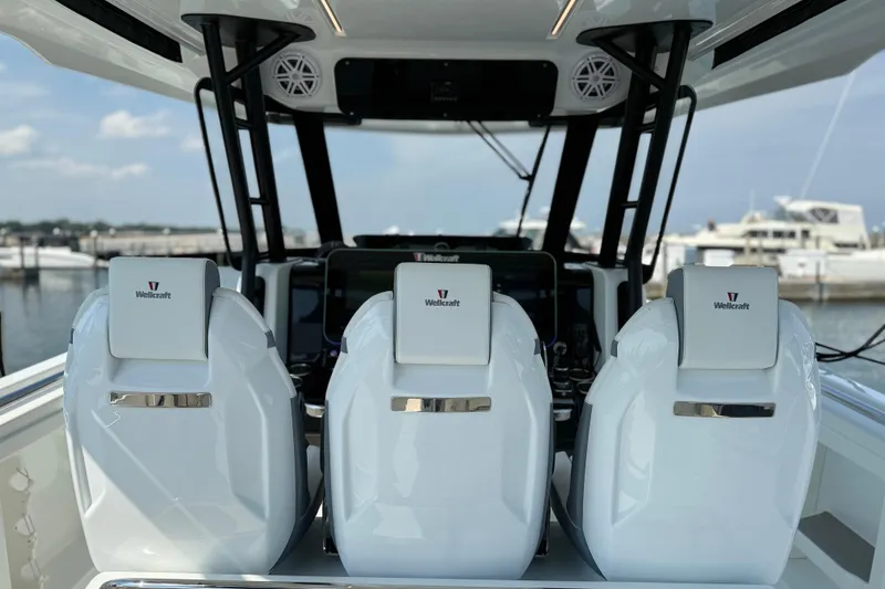Slide: The Image of 2026 Wellcraft 38 T-Top boat interior with three sleek white seats. - 22