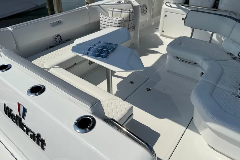 Slide: The Image of 2026 Wellcraft 38 T-Top boat interior with white seating and table, showcasing luxury design. - 25