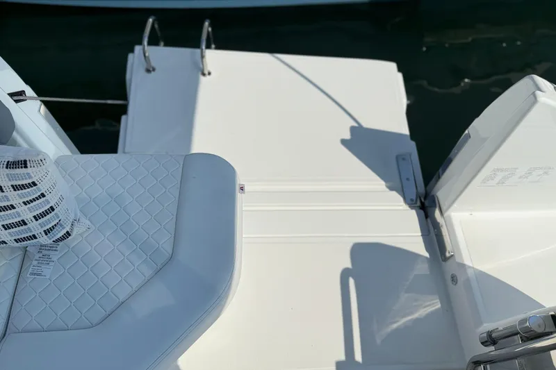 Slide: The Image of 2026 Wellcraft 38 T-Top boat deck with white seating and ladder. - 26