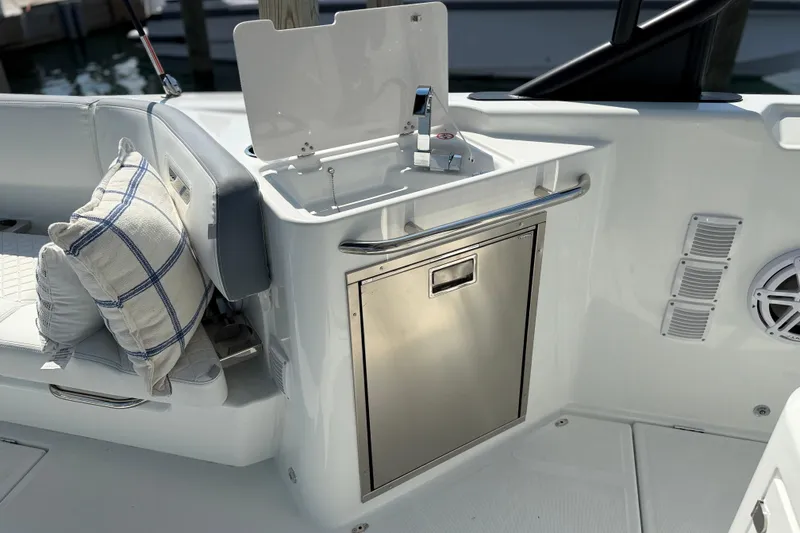Slide: The Image of 2026 Wellcraft 38 T-Top boat interior with sink, stainless steel cabinet, and cushioned seating. - 28