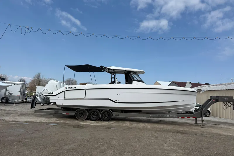 Slide: The Image of 2026 Wellcraft 38 T-Top boat on trailer under clear blue sky. - 30