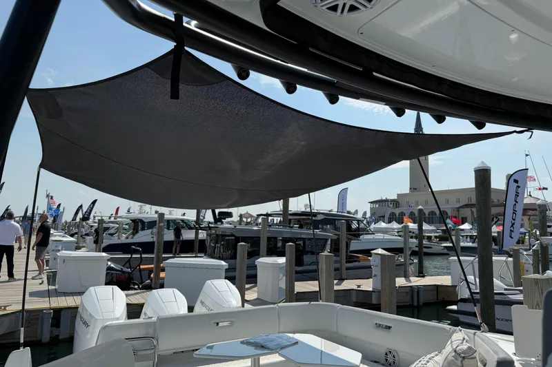 Slide: The Image of 2026 Wellcraft 38 T-Top boat at marina with shade canopy and docked vessels. - 34