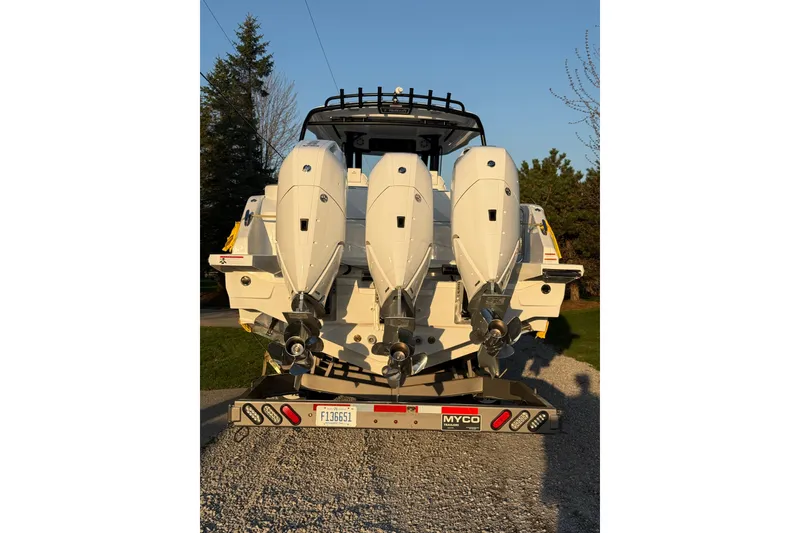 Slide: The Image of 2026 Wellcraft 38 T-Top boat with triple outboard engines on a trailer. - 38