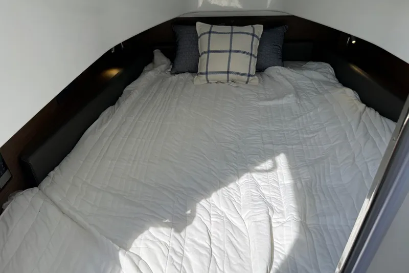 Slide: The Image of Cozy cabin bed in 2026 Wellcraft 38 T-Top boat with pillows and white bedding. - 9