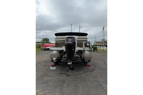 Slide: The Image of 2022 SUNTRACKER Party Barge 22 pontoon boat on trailer, parked outdoors. - 3